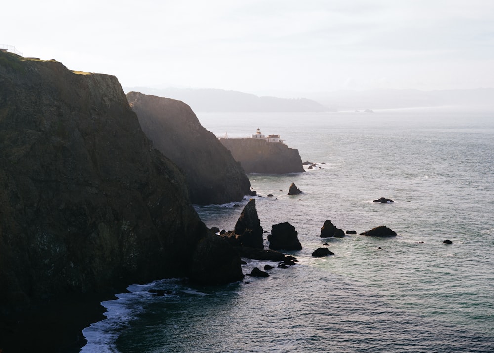 green and black rock formation on sea during daytime