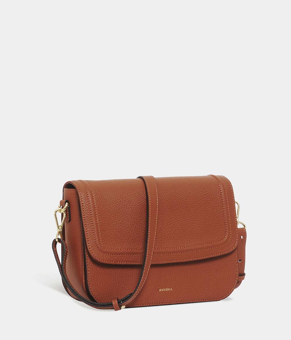 brown leather sling bag on white background