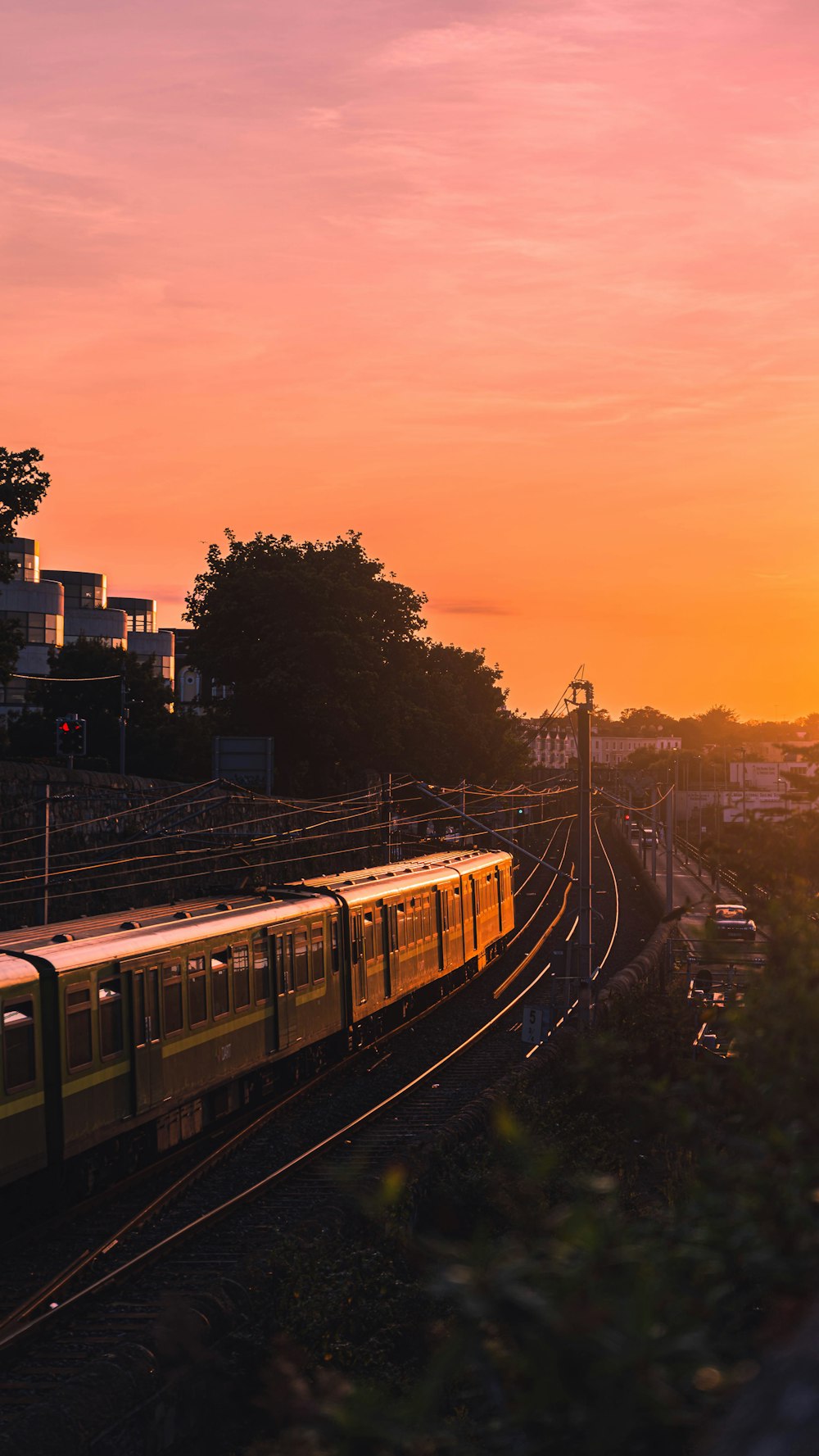 Train jaune et noir sur les voies ferrées au coucher du soleil