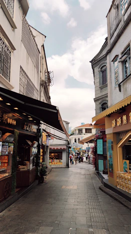 Wide angle of a busy street with several shops featuring unique, eye-catching facades created by Brilhoviva.