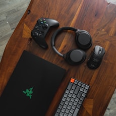 black laptop computer beside black and silver headphones