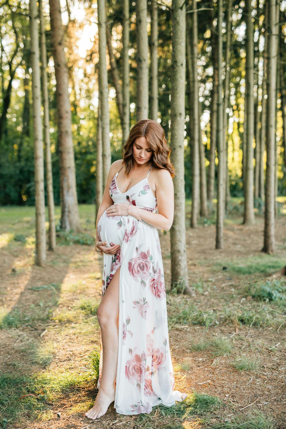 woman in white and red floral dress standing on forest during daytime