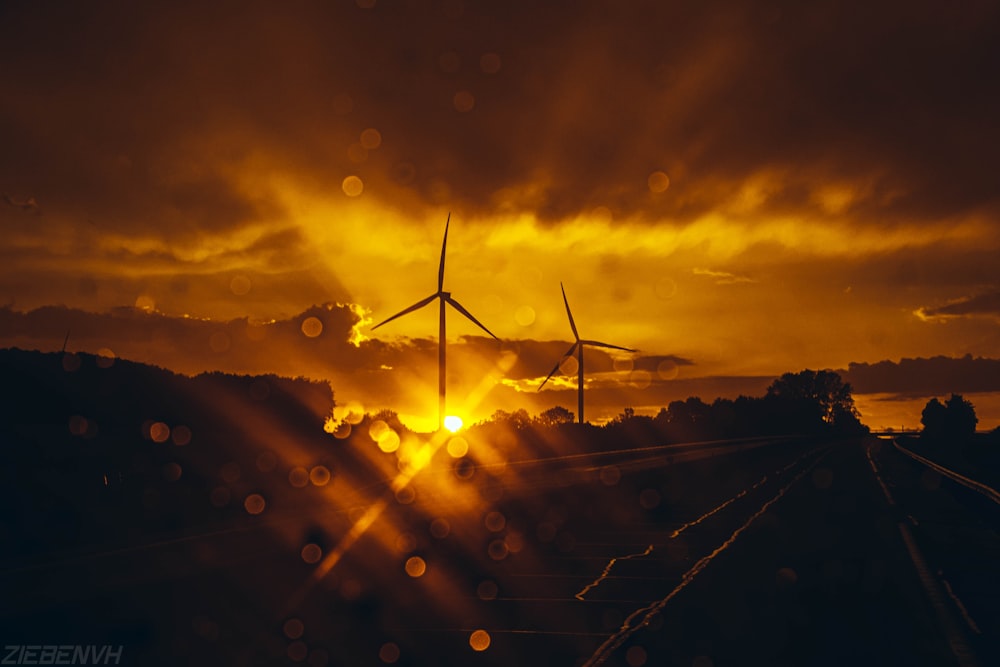 silhouette of wind turbines during sunset