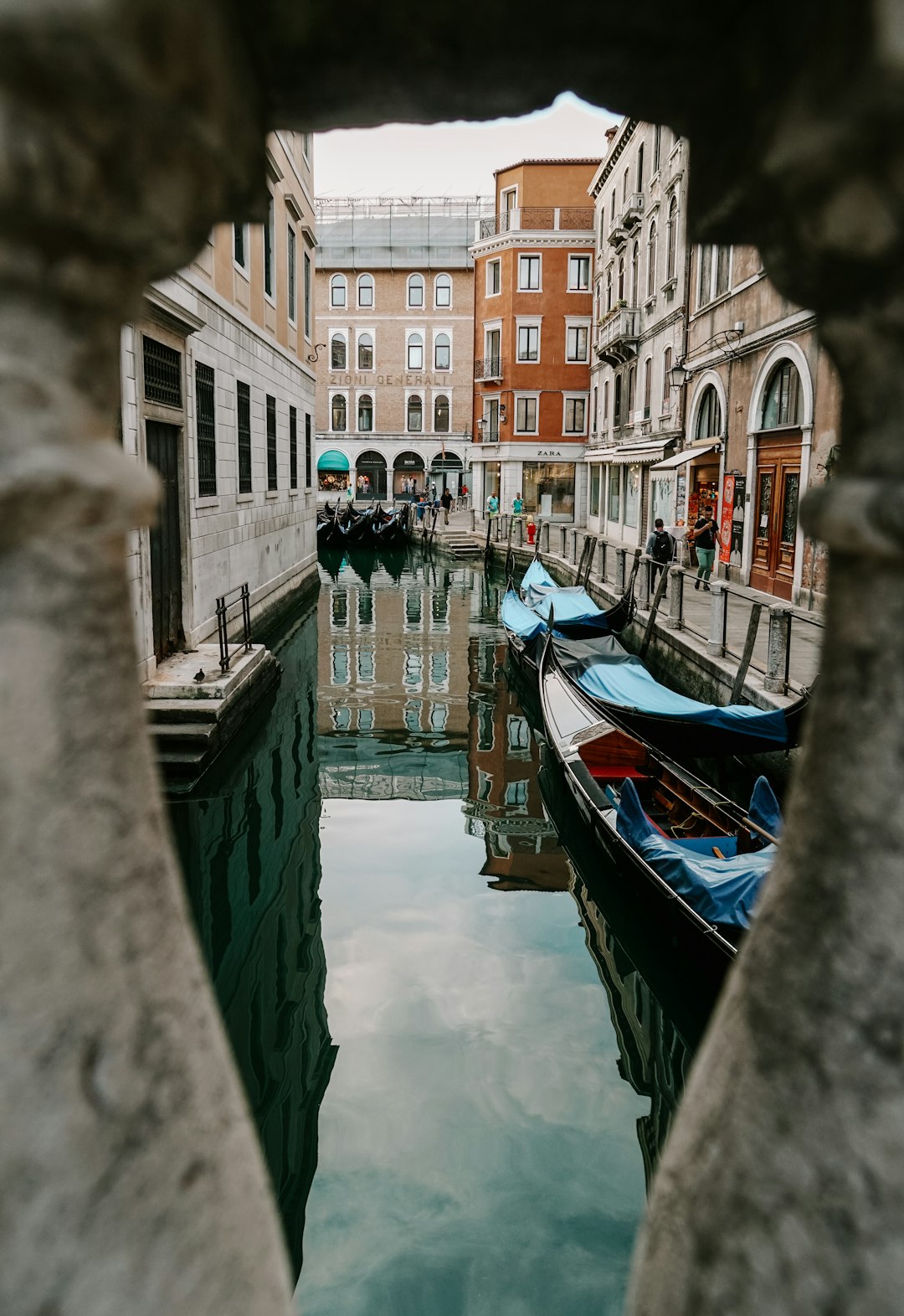 people riding on boat on river between buildings during daytime