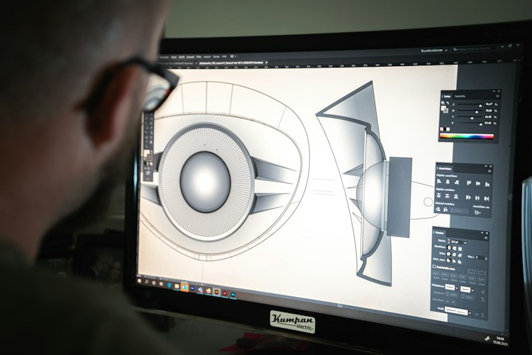 Game developer looking at lines of code and a game level layout on a large monitor