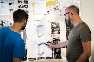 man in blue crew neck t-shirt holding white printer paper