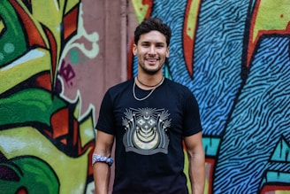 A confident man wearing a sparrownest t-shirt, standing proudly with a relaxed smile.