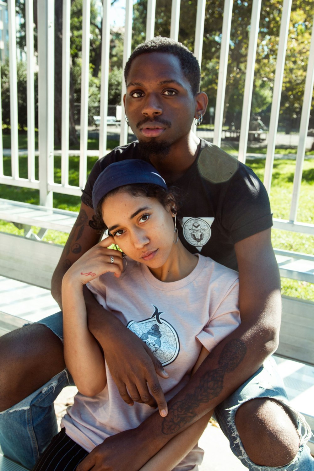 man in grey crew neck t-shirt sitting beside girl in black cap