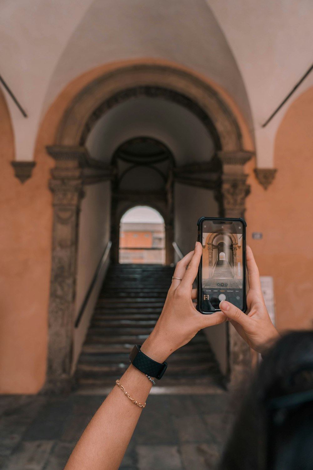 Persona sosteniendo un teléfono inteligente negro tomando una foto del pasillo