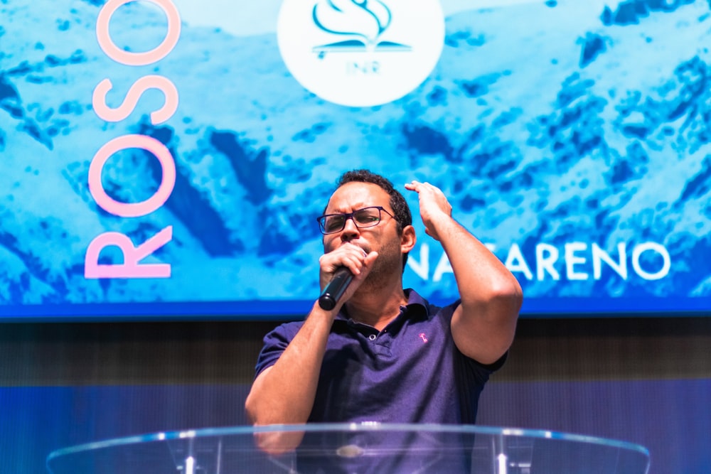 man in black polo shirt holding microphone