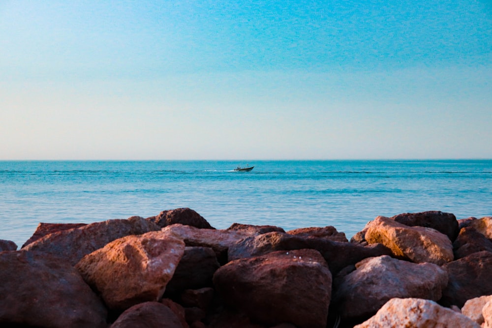 brown rocks near body of water during daytime