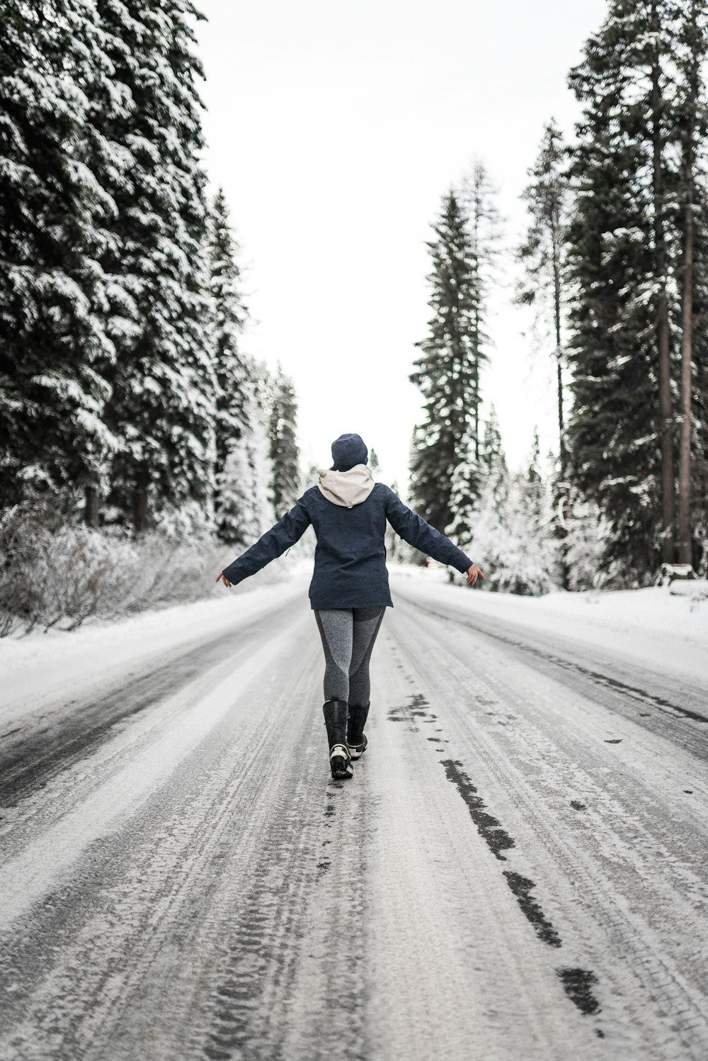 man in blue jacket and black pants running on road during daytime