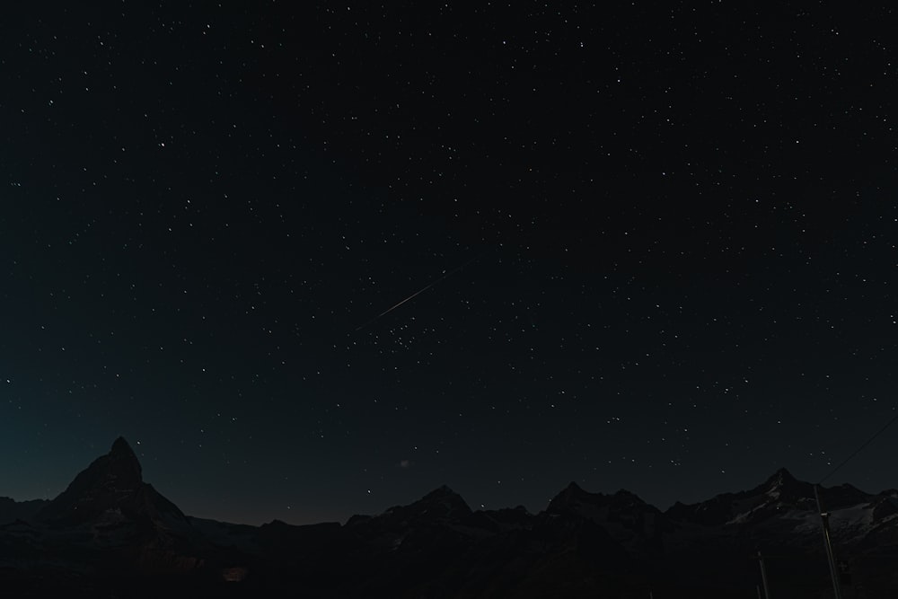 silhouette of mountain under starry night