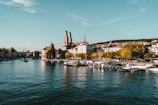 white and brown boat on body of water near city buildings during daytime
