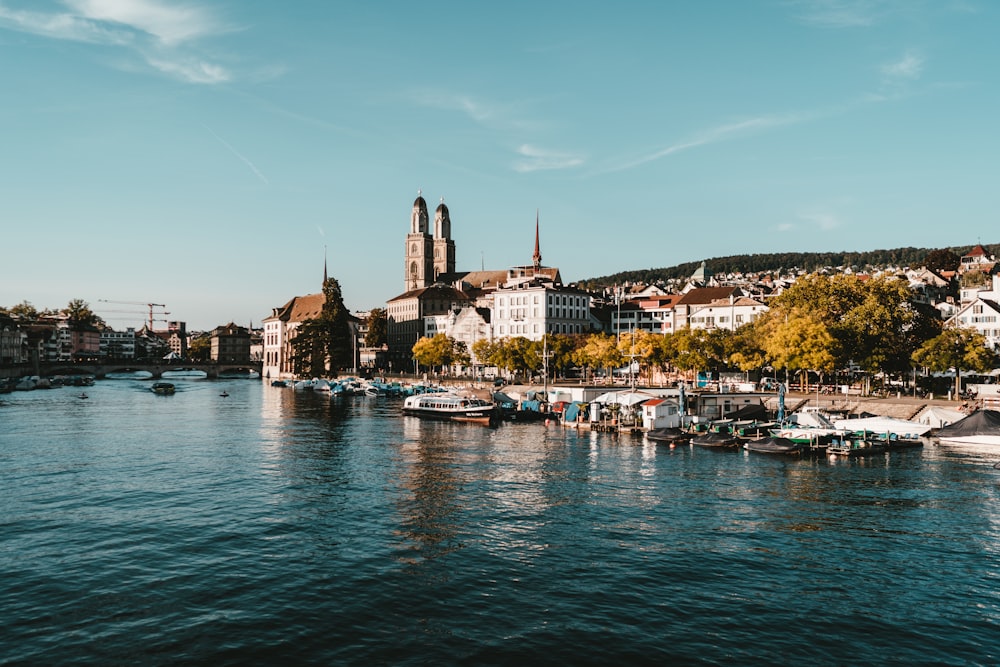 weißes und braunes Boot tagsüber auf Gewässern in der Nähe von Stadtgebäuden