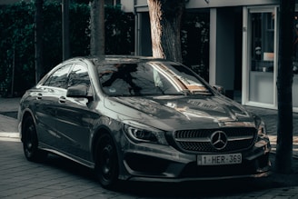 black mercedes benz c class parked on sidewalk during daytime