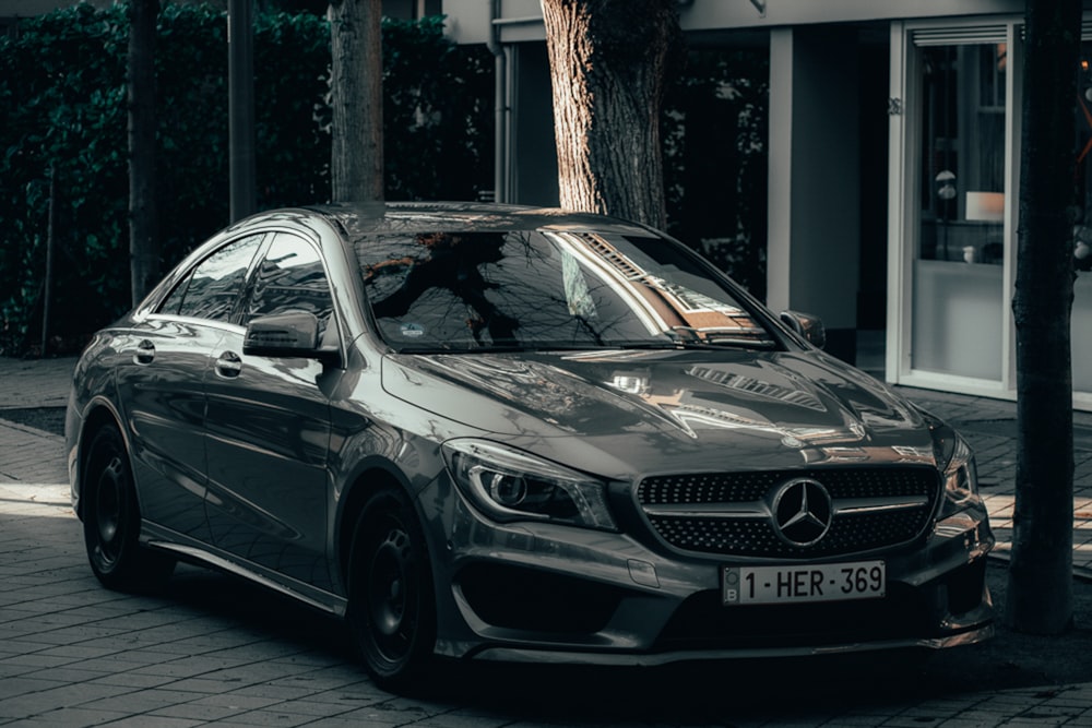 black mercedes benz c class parked on sidewalk during daytime