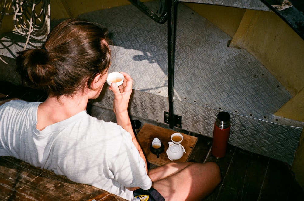 woman in white t-shirt sitting on floor