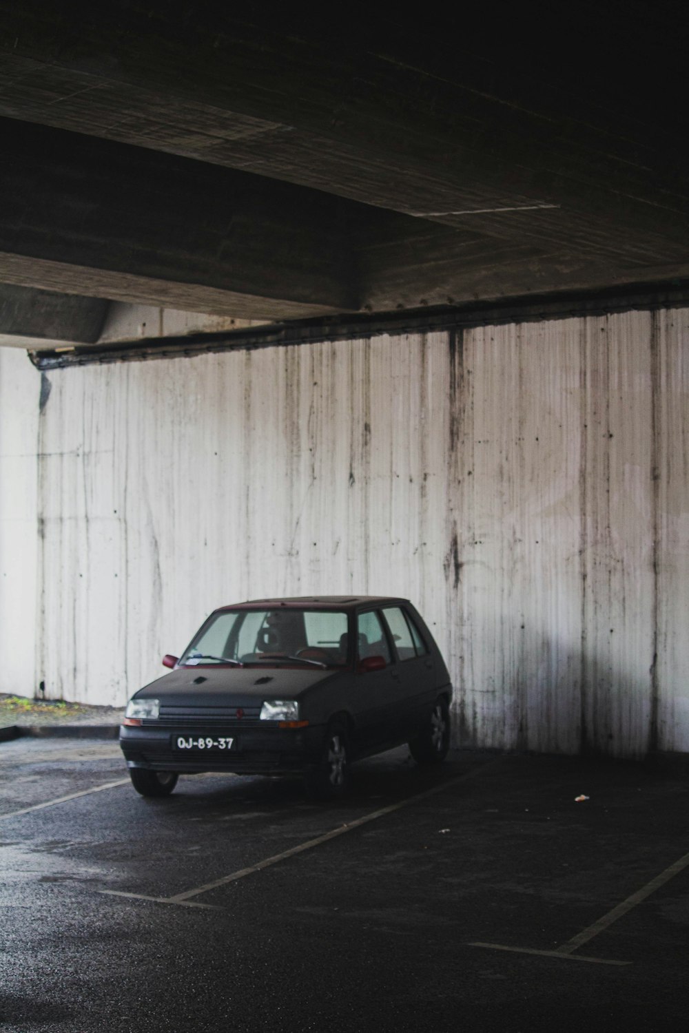 black car parked beside white wooden fence