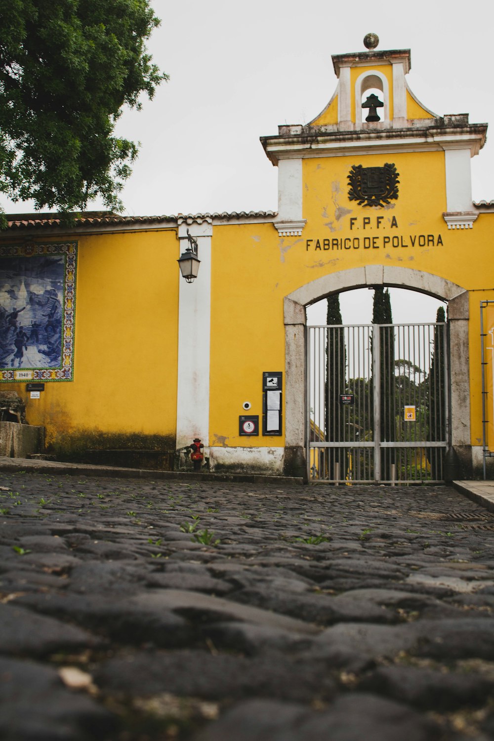 yellow concrete building with black metal gate