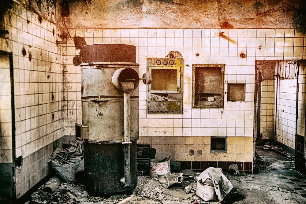 black trash bin beside white wall tiles