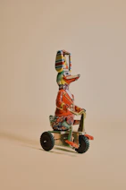 brown and red robot riding on red and black trike