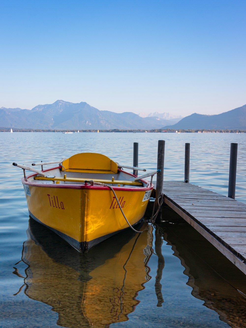 gelb-weißes Boot tagsüber am Dock