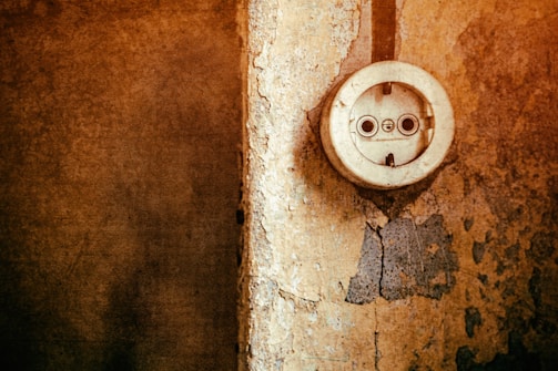 An electrician upgrading old electrical wiring in a vintage Paris apartment.
