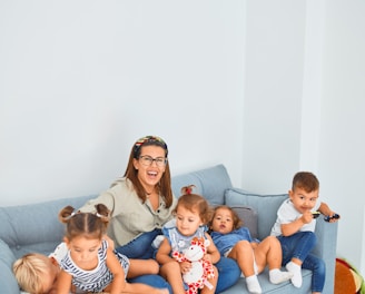 3 women sitting on gray couch