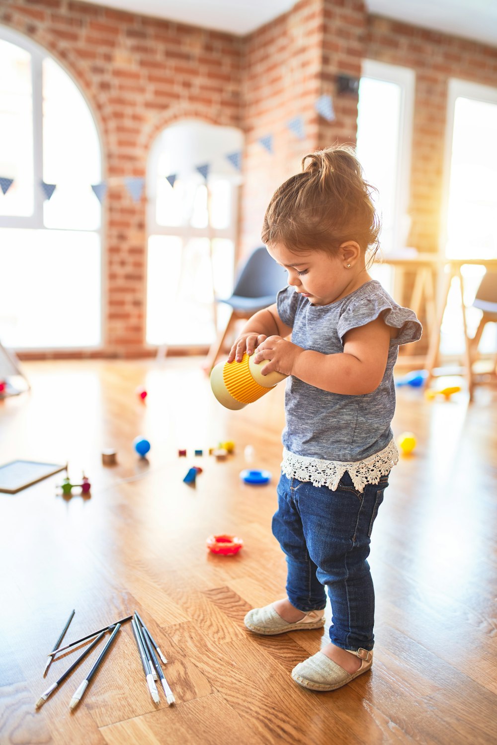 girl in blue denim dungaree pants holding blue and white polka dot handbag