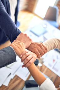 team members gripping wrists in unity gesture