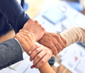 person in black long sleeve shirt holding persons hand