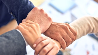 person in black long sleeve shirt holding persons hand