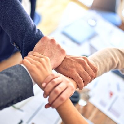 Group of business workers standing with hands together doing symbol at the office