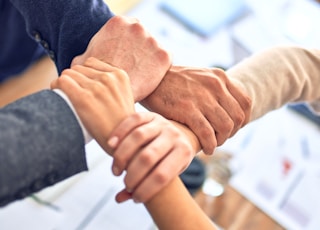 Group of business workers standing with hands together doing symbol at the office