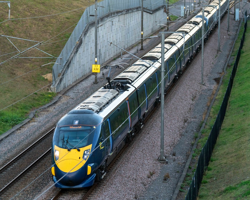 blue and yellow train on rail tracks