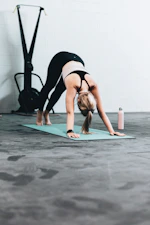 woman in black sports bra and blue denim jeans doing yoga