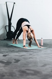 woman in black sports bra and blue denim jeans doing yoga