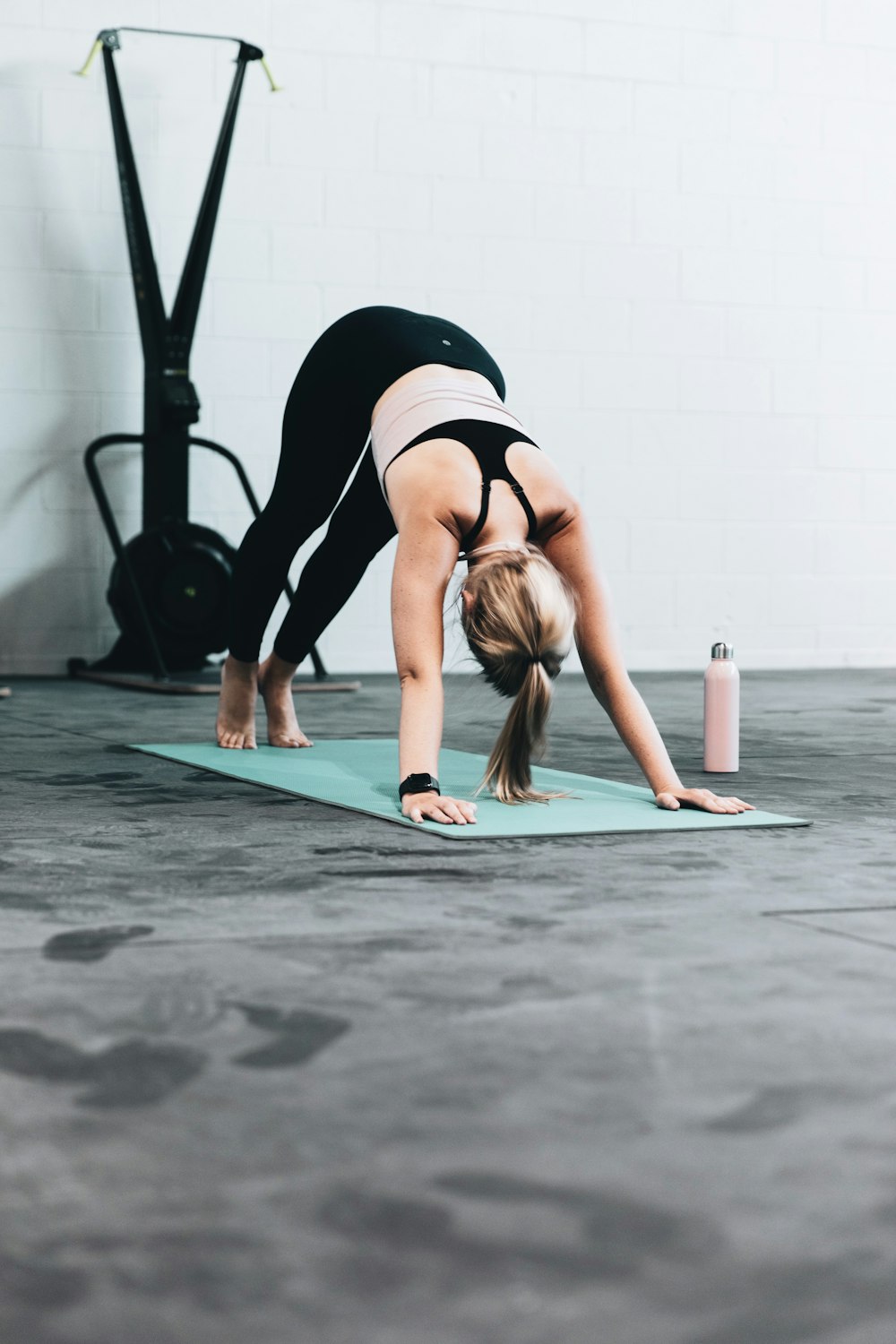 Frau in schwarzem Sport-BH und blauer Jeans beim Yoga