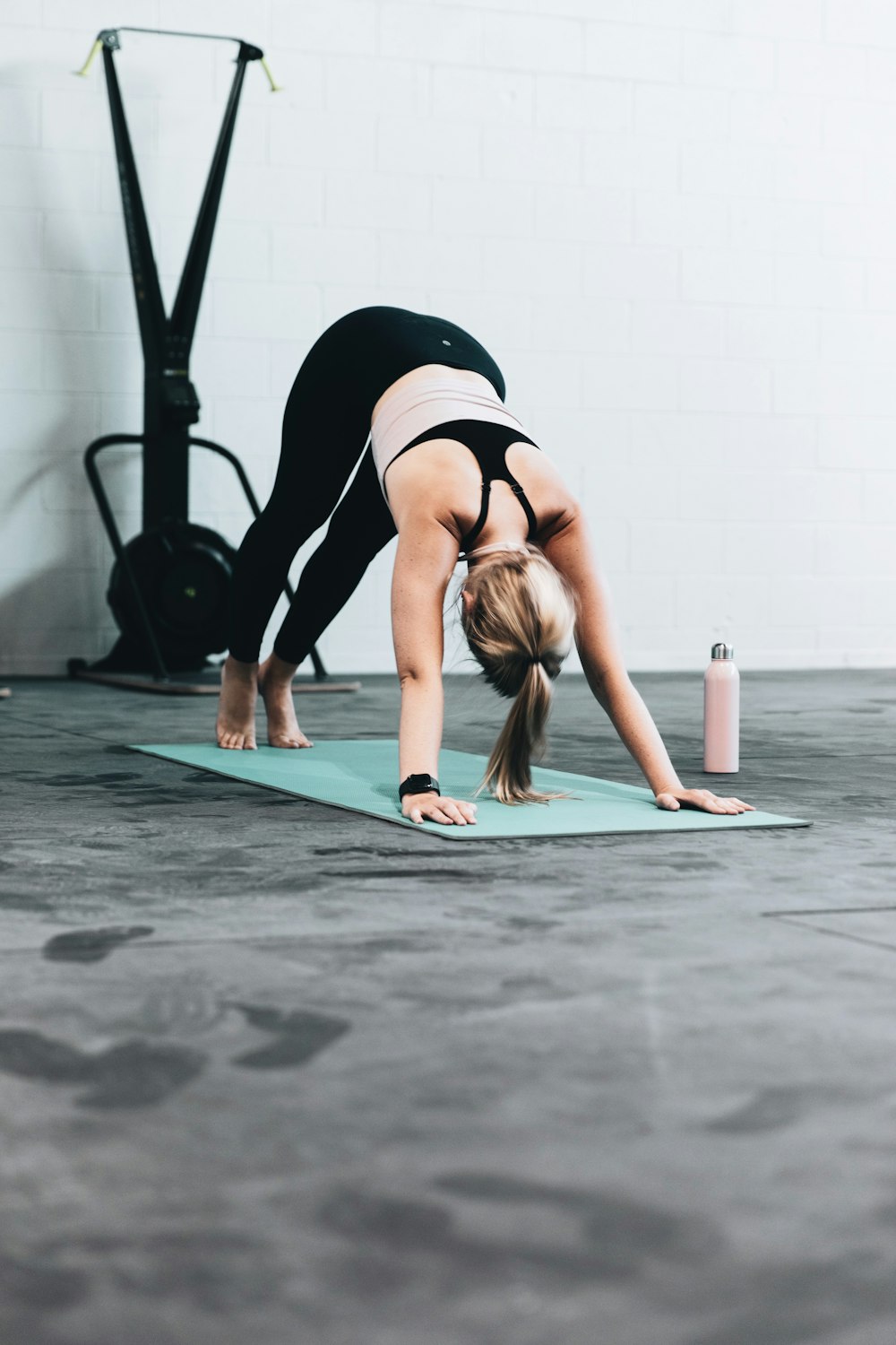 femme en soutien-gorge de sport noir et jean bleu faisant du yoga