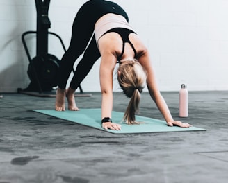 woman in black sports bra and blue denim jeans doing yoga