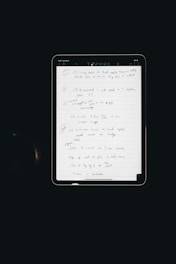 An electronic tablet displays a handwritten to-do list. The page, filled with various exercises and notes, is neatly organized with numbered bullet points and highlighted headings. The interface of the tablet is visible, with icons at the top indicating various functions such as drawing tools.