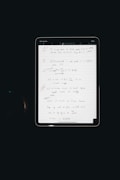 An electronic tablet displays a handwritten to-do list. The page, filled with various exercises and notes, is neatly organized with numbered bullet points and highlighted headings. The interface of the tablet is visible, with icons at the top indicating various functions such as drawing tools.