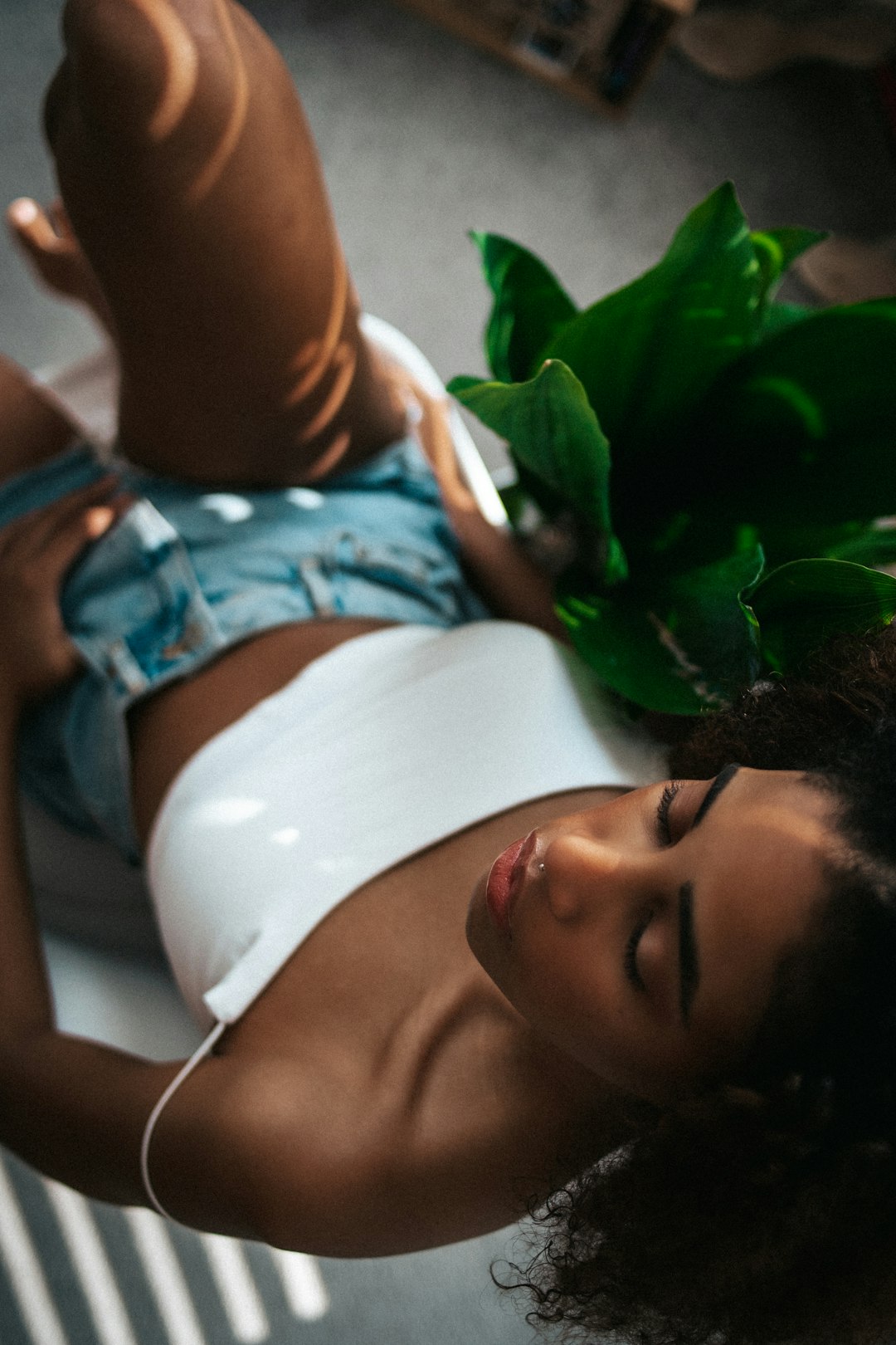 woman in white tank top lying on bed