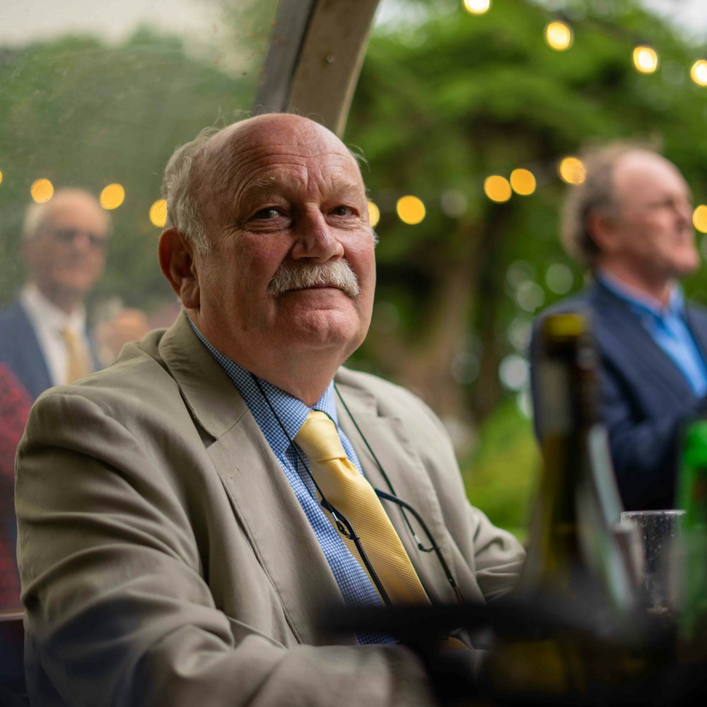 man in gray suit jacket sitting on chair