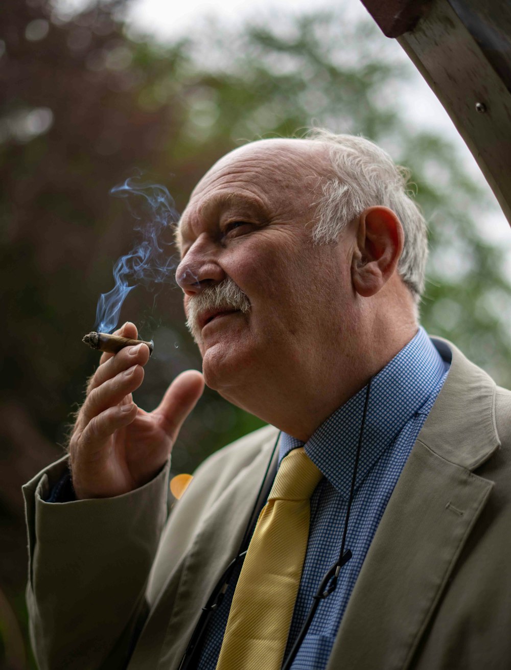 man in gray suit jacket smoking