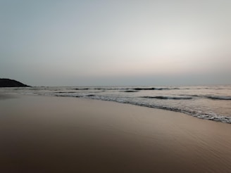A serene beach scene with gentle waves and a subtle overlay of a person thoughtfully preparing notes for a debate.