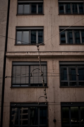 Close-up of telecom cables being installed on a tall building facade.