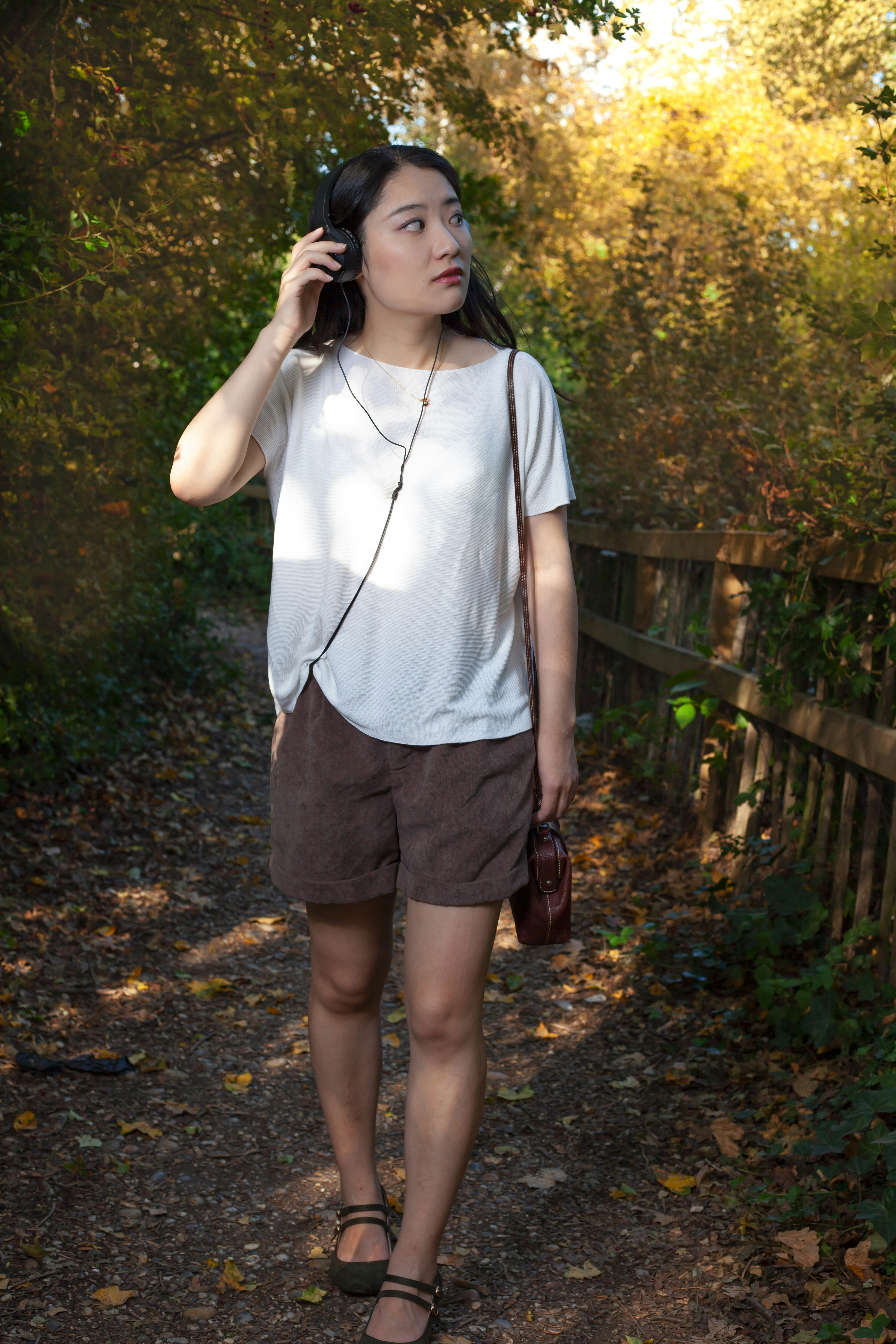 Femme en chemise blanche et short marron debout sur le sentier