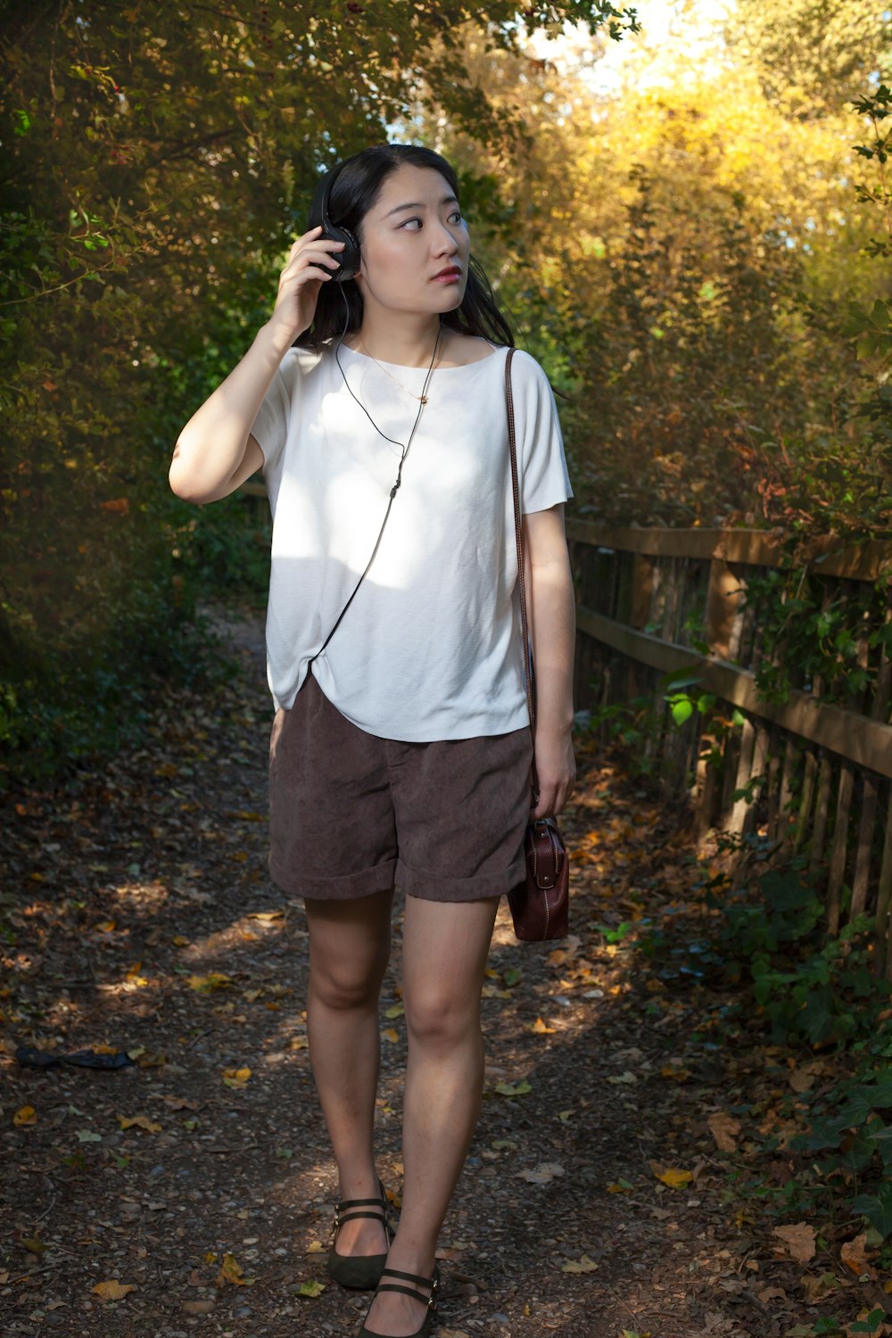 Woman in white shirt and brown shorts standing on pathway photo – Free  Clothing Image on Unsplash